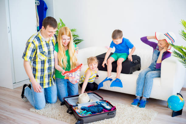 Family going on vacation Happy family going on vacation packing suitcases for a trip Leave All the Extras at Home for travel stock pictures, royalty-free photos & images